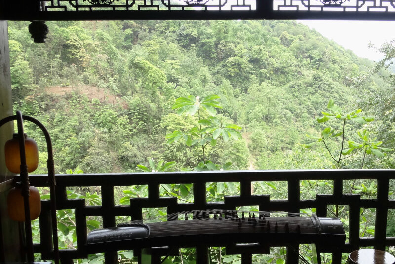 坐在木雕廊檐下的古筝前,面对青山绝对让你心旷