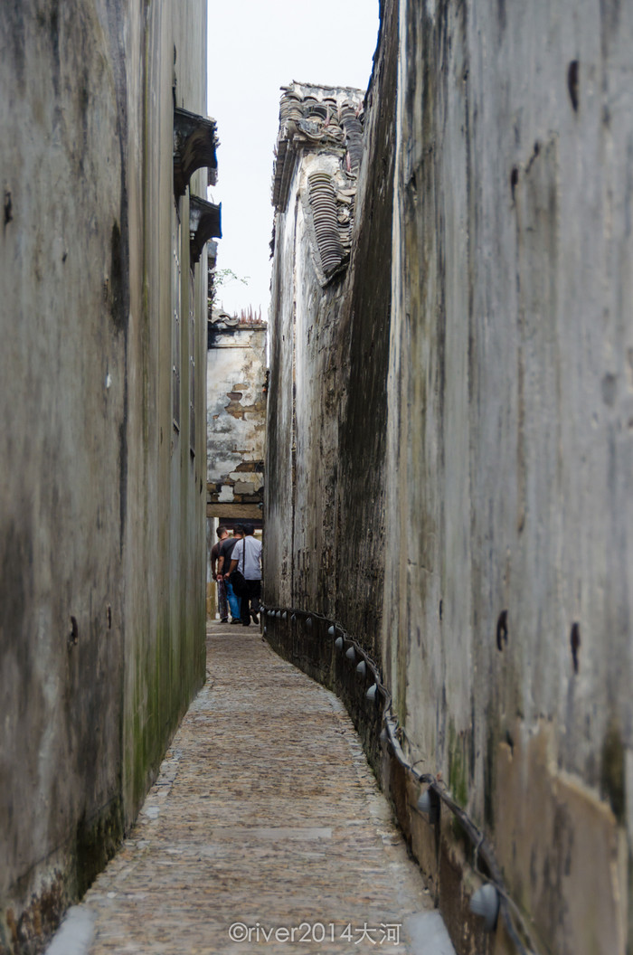 小巷子悠长窄小,显得两侧的墙壁更加高大墙体斑驳,尽是岁月的痕迹